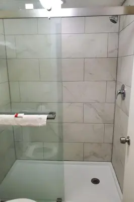 a bathroom with a shower with a glass door at Grove City Travel Inn South Columbus in Grove City
