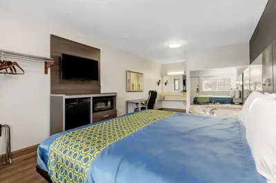a hotel room with a bed and a television at Grove City Travel Inn South Columbus in Grove City
