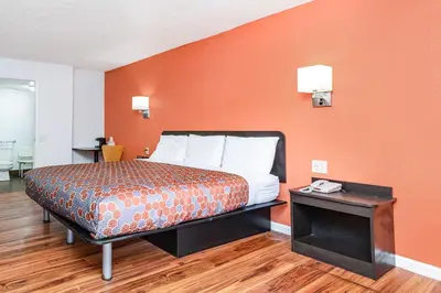 a bedroom with a bed with an orange wall at Relax Inn by OYO Columbus OH I 70 in Columbus