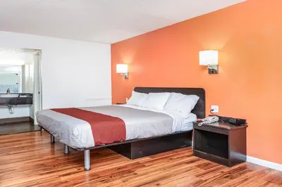 a bedroom with a bed with an orange wall at Relax Inn by OYO Columbus OH I 70 in Columbus