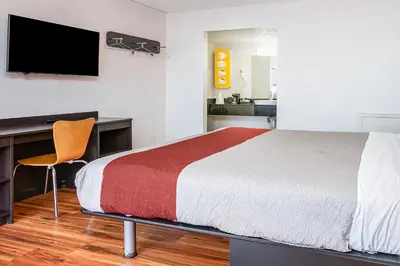 a bedroom with a bed and a desk and a television at Relax Inn by OYO Columbus OH I 70 in Columbus