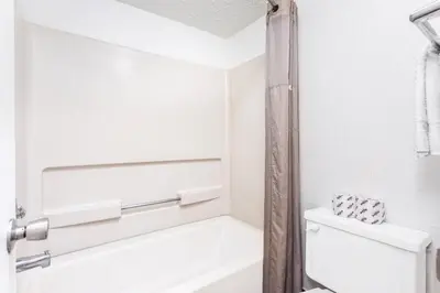 a white bathroom with a tub and a toilet at Relax Inn by OYO Columbus OH I 70 in Columbus