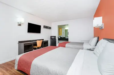 a hotel room with two beds and a desk at Relax Inn by OYO Columbus OH I 70 in Columbus