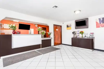 a lobby with a waiting room with flowers on the counter at Relax Inn by OYO Columbus OH I 70 in Columbus