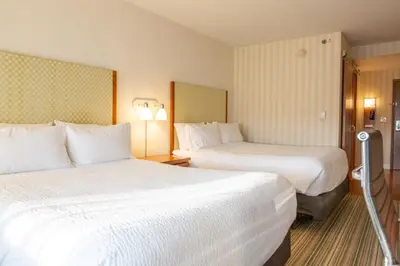 a hotel room with two beds with white sheets at Holiday Inn Express Columbus Airport Easton in Columbus