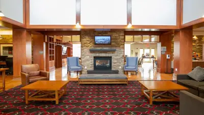 a lobby with a fireplace and a couch and chairs at Holiday Inn Express Columbus Airport Easton in Columbus