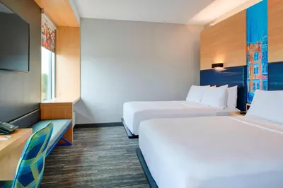 a hotel room with two beds and a television at Aloft Columbus Westerville in Westerville