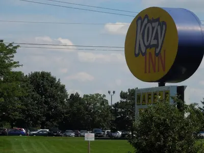 a sign for a kxm in a parking lot at Kozy Inn Columbus in Columbus