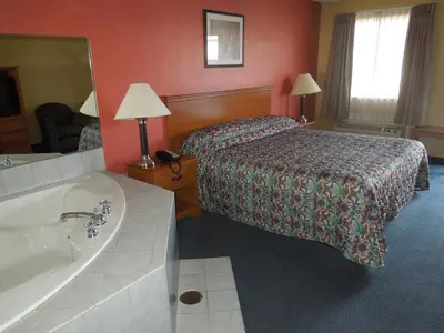 a hotel room with a bed and a bath tub at Kozy Inn Columbus in Columbus