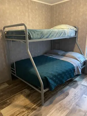a bunk bed in a room with a green bedsheet at Lake Point Motel in Marblehead