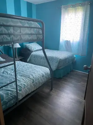 two bunk beds in a room with blue walls at Lake Point Motel in Marblehead