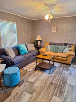 a living room with two couches and a coffee table at Lake Point Motel in Marblehead