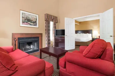 a living room with two red chairs and a fireplace at Hawthorn Extended Stay by Wyndham Columbus in Columbus