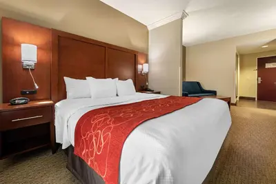 a hotel room with a large bed with a red blanket at Holiday Inn Express & Suites Hebron - Cincinnati Airport by IHG in Hebron