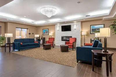 a lobby with couches and chairs and a fireplace at Holiday Inn Express & Suites Hebron - Cincinnati Airport by IHG in Hebron