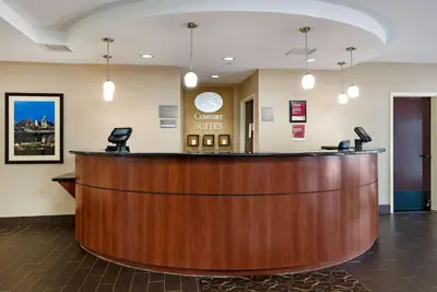 a hotel lobby with a large wooden reception desk at Holiday Inn Express & Suites Hebron - Cincinnati Airport by IHG in Hebron
