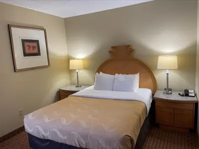 a hotel room with a bed with two night stands at Baymont by Wyndham Greenfield in Greenfield