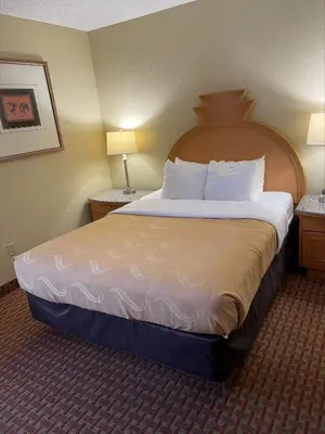 a hotel room with a large bed with white sheets at Baymont by Wyndham Greenfield in Greenfield
