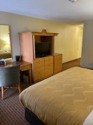 a hotel room with a bed and a desk and a television at Baymont by Wyndham Greenfield in Greenfield