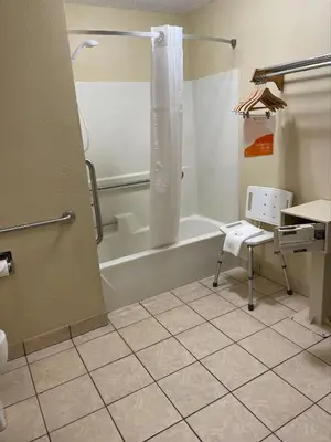 a bathroom with a shower and a tub and a sink at Baymont by Wyndham Greenfield in Greenfield
