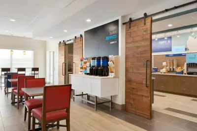 a restaurant with a table and chairs and a counter at Holiday Inn Express & Suites - Cincinnati NE - Red Bank Road by IHG in Cincinnati