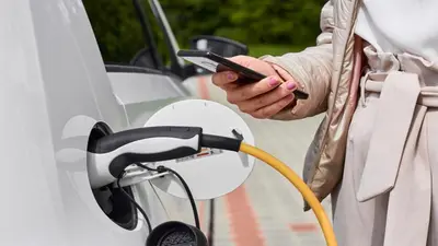 a person is fueling a car with a cell phone at Holiday Inn Express & Suites - Cincinnati NE - Red Bank Road by IHG in Cincinnati