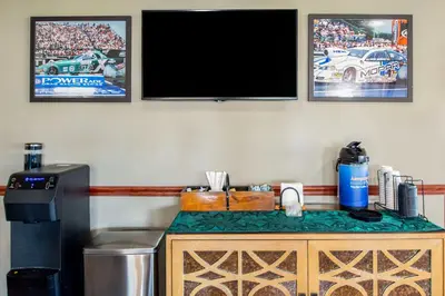 a tv on a wall next to a counter with a trash can at Best Western Lakewood Inn in Hebron