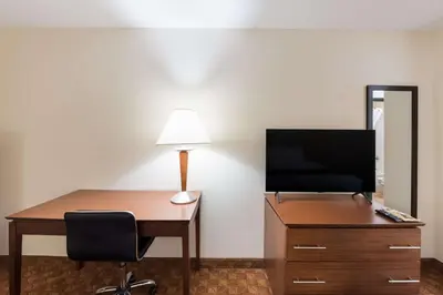 a desk with a television and a lamp on a dresser at Best Western Lakewood Inn in Hebron