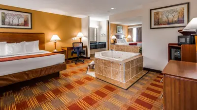 a hotel room with a bed and a bath tub at Best Western Lakewood Inn in Hebron