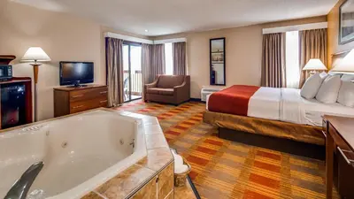 a hotel room with a bed and a tub at Best Western Lakewood Inn in Hebron