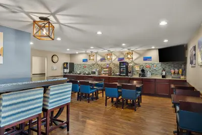 a restaurant with blue chairs and a bar at Best Western Lakewood Inn in Hebron