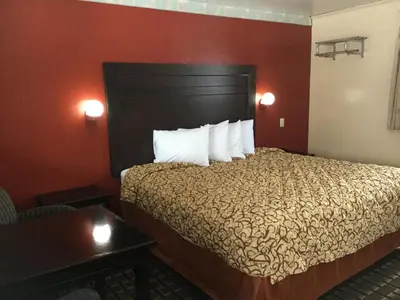a hotel room with a bed with white pillows at Best Motel in Johnston Corners