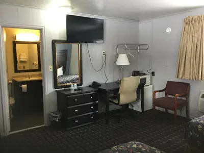 a hotel room with a desk and a mirror at Best Motel in Johnston Corners