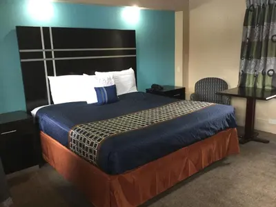 a bedroom with a large bed with a blue wall at Best Motel in Johnston Corners