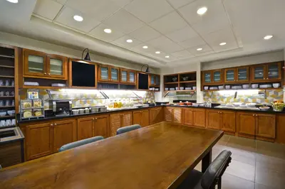a large kitchen with a wooden table and chairs at Hyatt Place Columbus Worthington in Worthington