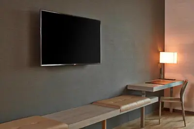 a room with a tv on a wall with a bench at AC Hotel Columbus Dublin in Dublin