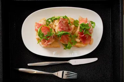 a white plate of food with pasta and bacon at AC Hotel Columbus Dublin in Dublin