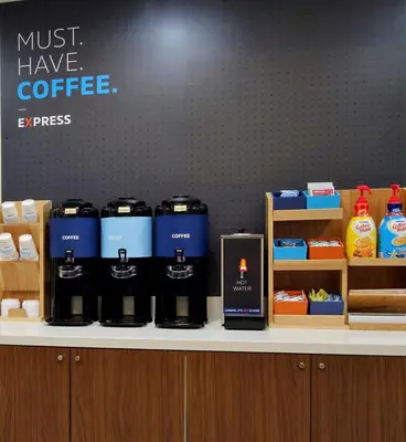 a counter with several bottles of coffee on it at Holiday Inn Express - Akron NW - Fairlawn by IHG in Akron