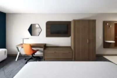 a bedroom with a bed and a desk with a computer at Holiday Inn Express - Akron NW - Fairlawn by IHG in Akron