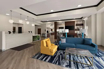 a living room with a blue couch and a yellow chair at Comfort Suites Columbus East Broad in Columbus