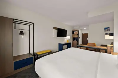 a room with a large white bed and a table at Comfort Suites Columbus East Broad in Columbus