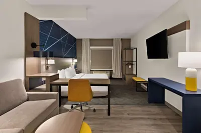 a hotel room with a bed and a desk at Comfort Suites Columbus East Broad in Columbus