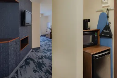 a room with a kitchen with a microwave and a tv at Fairfield Inn & Suites by Marriott Dayton Troy in Troy