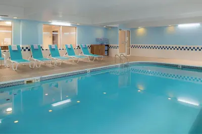 a large swimming pool with blue chairs in a room at Fairfield Inn & Suites by Marriott Dayton Troy in Troy