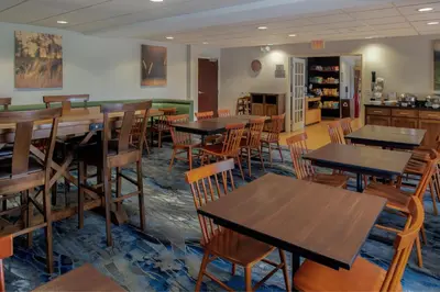 a dining room with wooden tables and chairs at Fairfield Inn & Suites by Marriott Dayton Troy in Troy