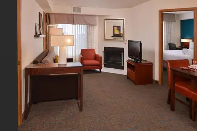 a hotel room with a living room with a bed and a television at Residence Inn by Marriott Dayton Troy in Troy