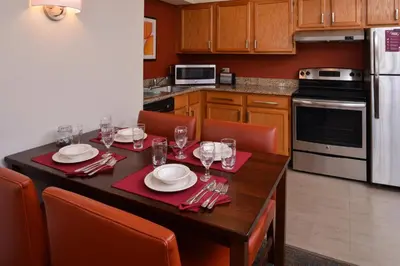 a kitchen with a table with plates and wine glasses at Residence Inn by Marriott Dayton Troy in Troy