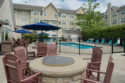 a patio with a table and chairs and a pool at Residence Inn by Marriott Dayton Troy in Troy