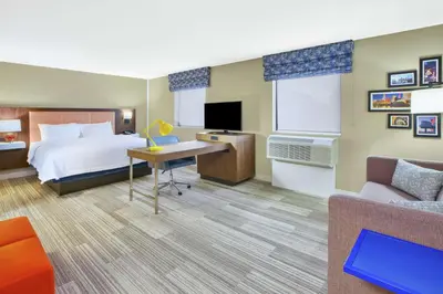a hotel room with a bed and a couch at Hampton Inn & Suites Oakwood Village-Cleveland in Oakwood