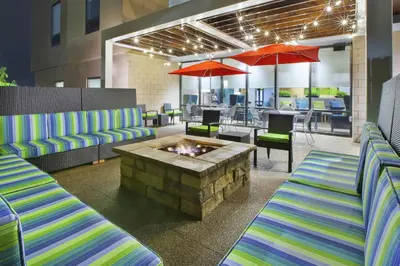 a restaurant with two couches and a fire pit at Home2 Suites By Hilton Pittsburgh Area Beaver Valley in Monaca